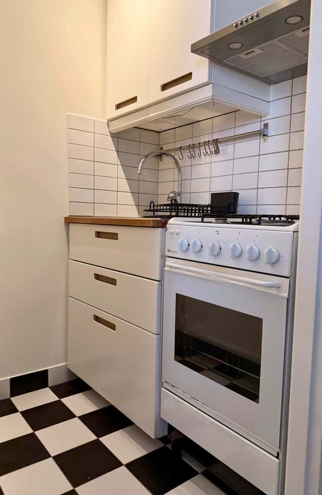 Södermalm studio interior, cozy living area by the water, modern kitchenette, café-lined streets nearby