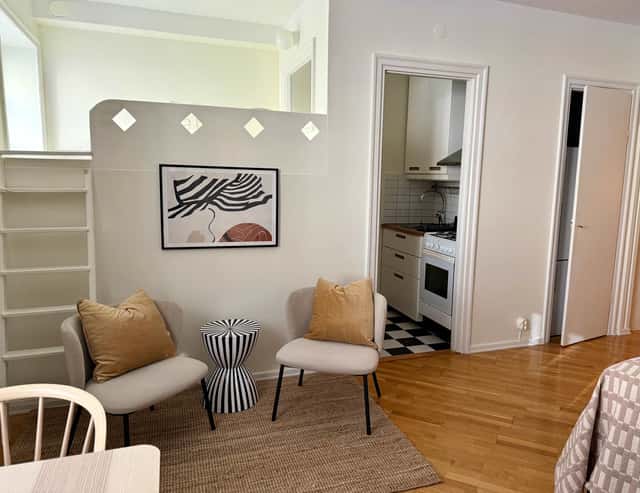 Södermalm studio interior, cozy living area by the water, modern kitchenette, café-lined streets nearby
