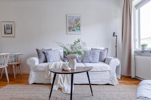 Living room with sofa bed and dining table in a cozy Globen apartment.