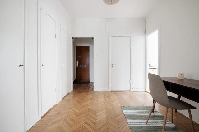 Ljust lägenhetsinteriör i Sundbyberg med minimalistisk inredning och grönskande omgivningar