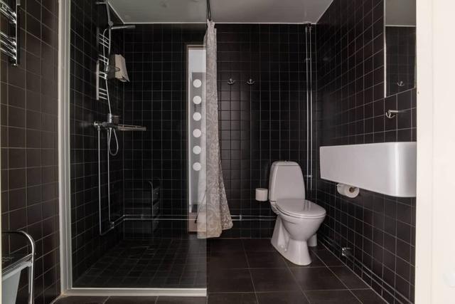 Studio living area, compact kitchen with microwave, bathroom with shower, storage hallway, panoramic lake view