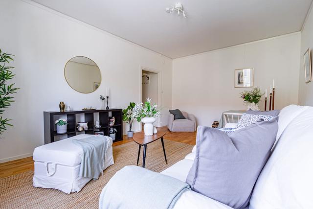 Living room with sofa bed and dining table in a cozy Globen apartment.