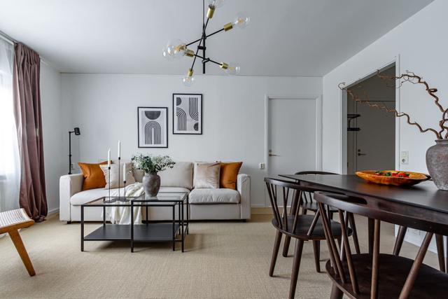 Living room with sofa bed and dining table in Södermalm apartment