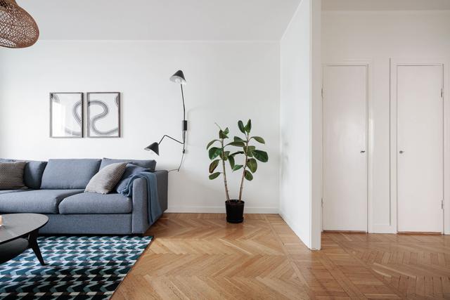 Ljust lägenhetsinteriör i Sundbyberg med minimalistisk inredning och grönskande omgivningar