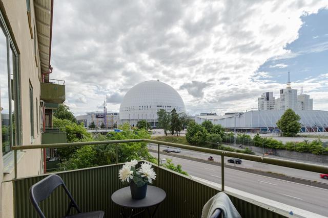 Bekvämt vardagsrum med balkongåtkomst i Globen-lägenhet