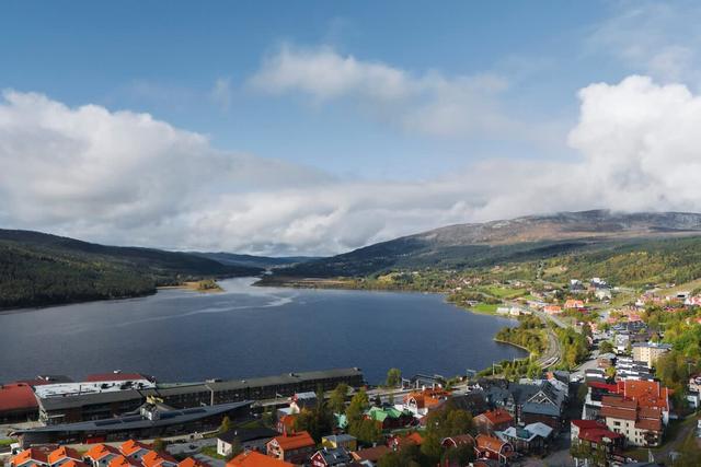 Sov- och vardagsrum, kompakt kök med mikrovågsugn, badrum med dusch, förvaringshall, panoramautsikt över sjön