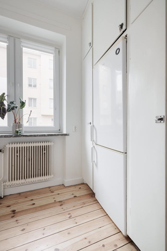 Ljust lägenhetsinteriör i Sundbyberg med minimalistisk inredning och grönskande omgivningar