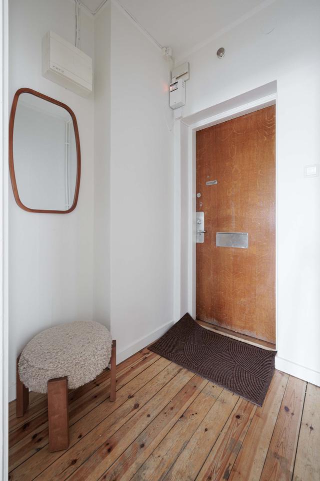 Ljust lägenhetsinteriör i Sundbyberg med minimalistisk inredning och grönskande omgivningar