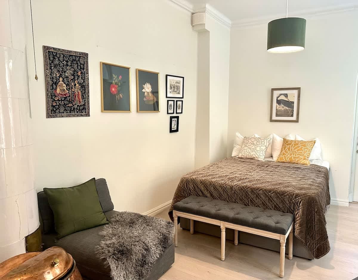 Sunlit bedroom with large windows and high ceilings in an Old Town Stockholm Airbnb near Stortorget and Royal Palace