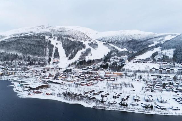 Sov- och vardagsrum, kompakt kök med mikrovågsugn, badrum med dusch, förvaringshall, panoramautsikt över sjön