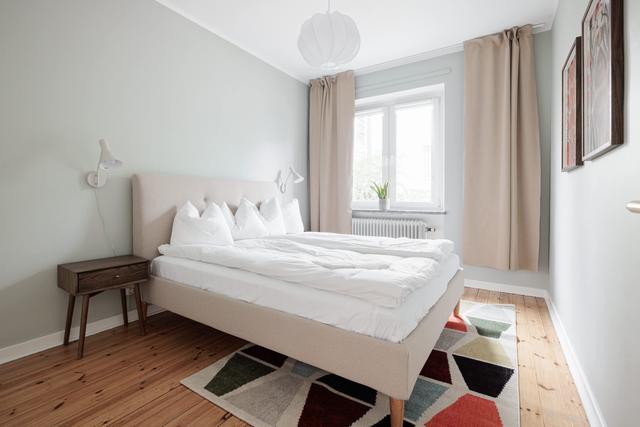 Ljust lägenhetsinteriör i Sundbyberg med minimalistisk inredning och grönskande omgivningar