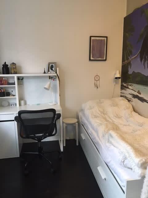 Ljust vardagsrum med soffa och konst i lägenhet på Södermalm; Stort sovrum med dubbelsäng på Södermalm; Enkelt sovrum på Södermalm; Ytterligare enkelt sovrum på Södermalm; Utrustat kök med spis och kyl på Södermalm; Privat terrass på lugn gata i Södermalm