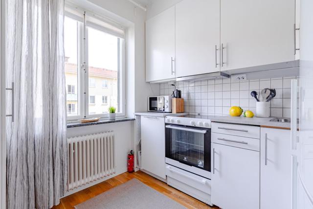 Living room with sofa bed and dining table in a cozy Globen apartment.