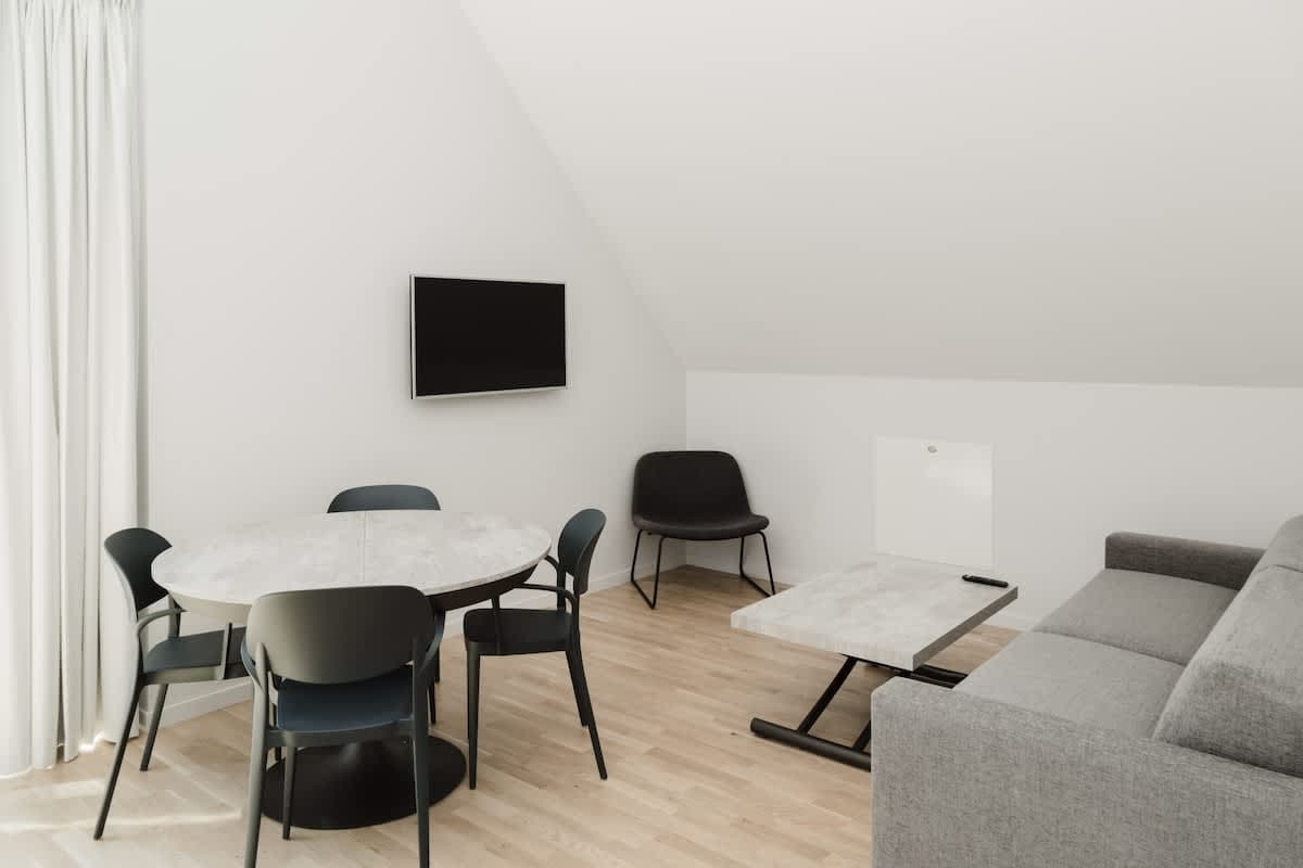 Loft living area in Lidingö, minimalist décor & natural light; modern kitchenette; cozy bedroom with workspace