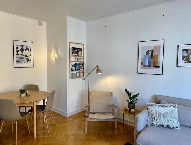 Vardagsrum i Södermalmslägenhet med matbord, bäddsoffa och läshörna