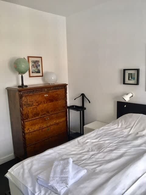 Bright living room with sofa and art in Södermalm apartment; Master bedroom with double bed in Södermalm; Single bedroom in Södermalm; Additional single bedroom in Södermalm; Equipped kitchen in Södermalm; Private terrace in Södermalm