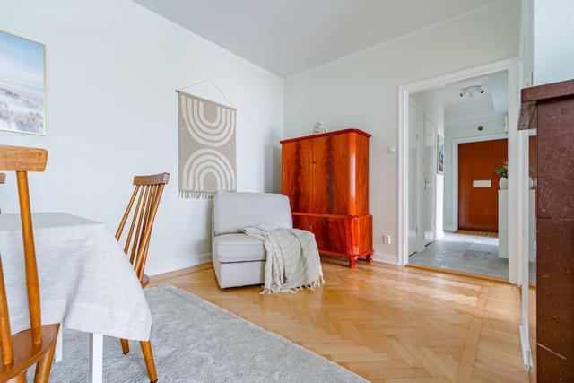 Living room with sofa bed and armchair in Kungsholmen apartment.