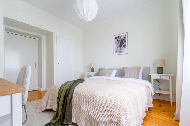 Living room with sofa bed and armchair in Kungsholmen apartment.