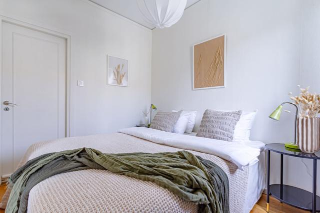 Living room with sofa bed and dining table in a cozy Globen apartment.