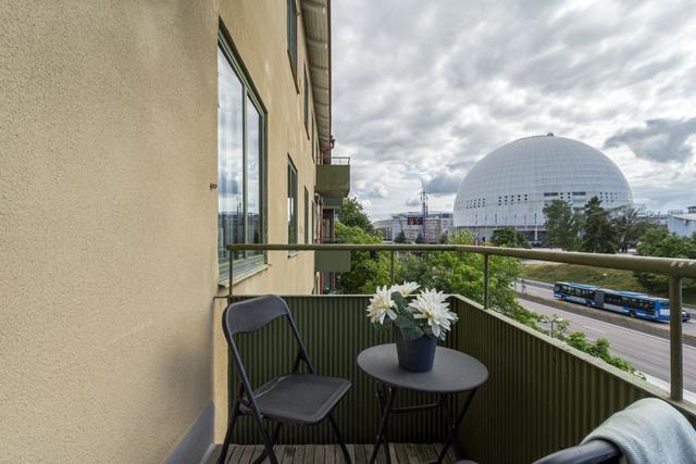 Bekvämt vardagsrum med balkongåtkomst i Globen-lägenhet