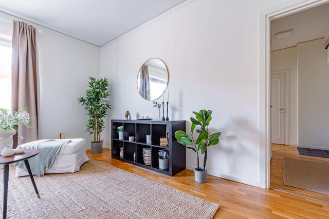 Living room with sofa bed and dining table in a cozy Globen apartment.