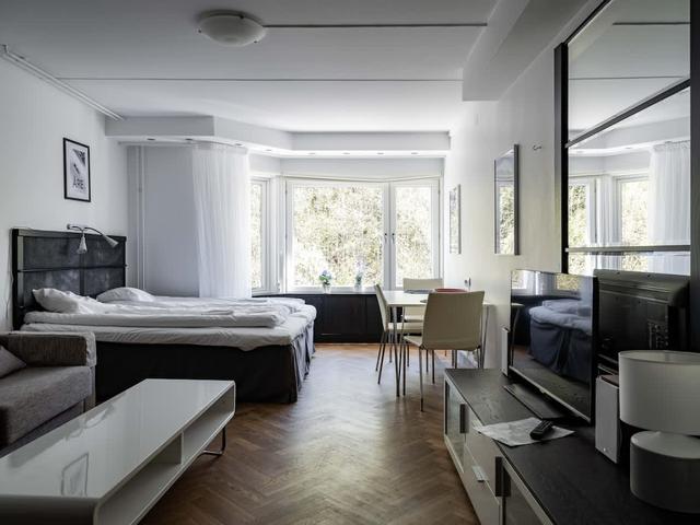 Studiovardagsrum i Stockholm med stora fönster och mysig sittgrupp