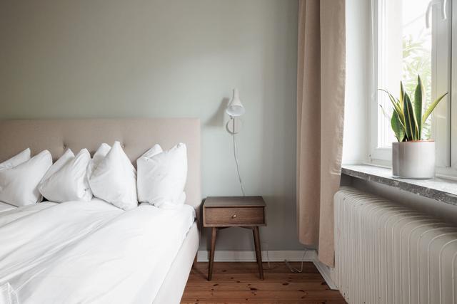 Ljust lägenhetsinteriör i Sundbyberg med minimalistisk inredning och grönskande omgivningar