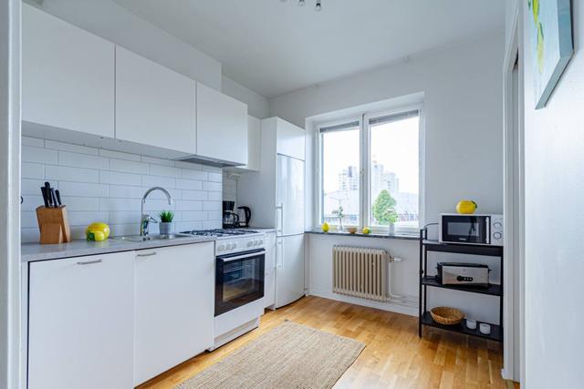 Comfortable living room with balcony access in Globen apartment