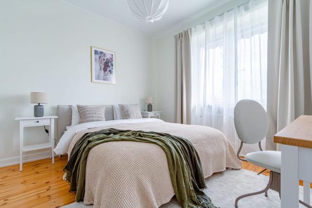 Living room with sofa bed and armchair in Kungsholmen apartment.