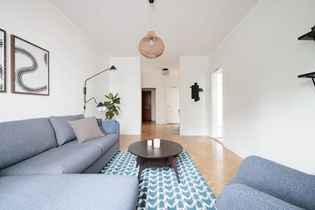 Ljust lägenhetsinteriör i Sundbyberg med minimalistisk inredning och grönskande omgivningar