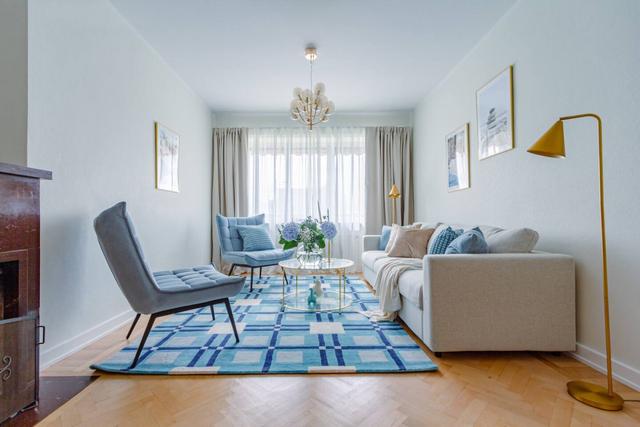 Living room with sofa bed and armchair in Kungsholmen apartment.