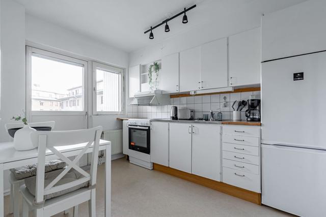 Living room with sofa bed and dining table in Södermalm apartment