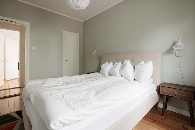 Ljust lägenhetsinteriör i Sundbyberg med minimalistisk inredning och grönskande omgivningar