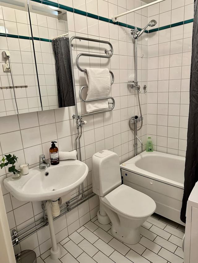 Vardagsrum i Södermalmslägenhet med matbord, bäddsoffa och läshörna