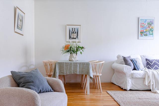 Living room with sofa bed and dining table in a cozy Globen apartment.