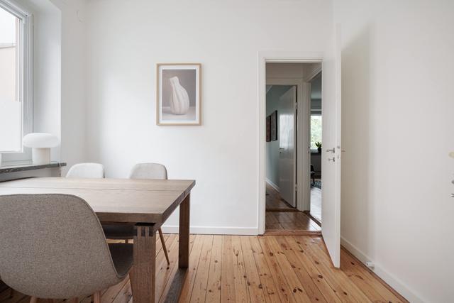 Ljust lägenhetsinteriör i Sundbyberg med minimalistisk inredning och grönskande omgivningar