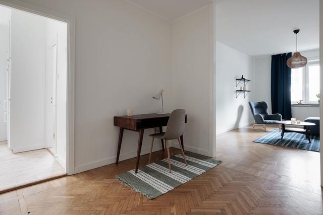 Ljust lägenhetsinteriör i Sundbyberg med minimalistisk inredning och grönskande omgivningar