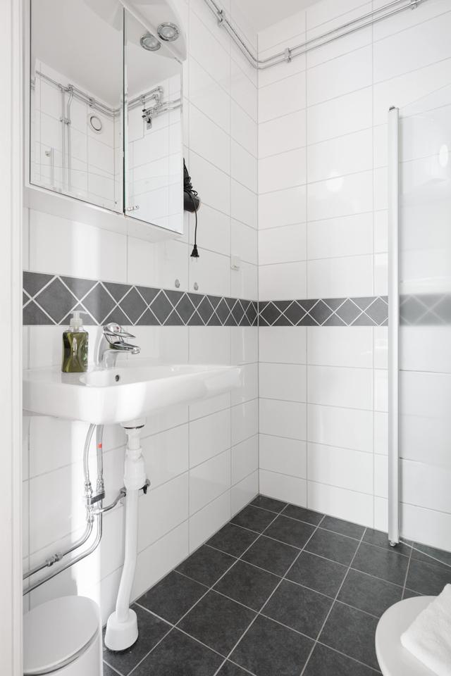 Ljust lägenhetsinteriör i Sundbyberg med minimalistisk inredning och grönskande omgivningar