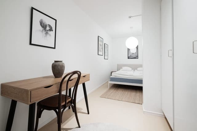 Interiörvy av en SoFo-lägenhet i Stockholm med bäddsoffa, sovrumslådor och arbetsplats