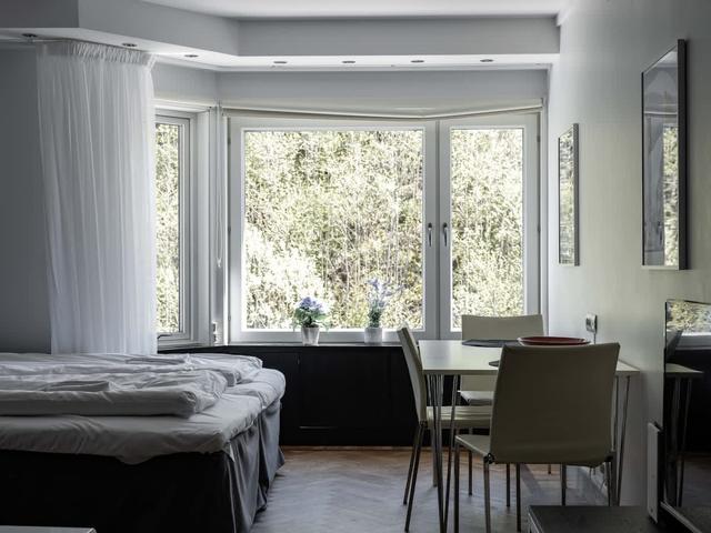 Studiovardagsrum i Stockholm med stora fönster och mysig sittgrupp