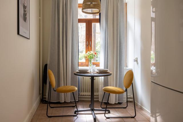 Cozy dining area for two by the large window in Gothenburg.