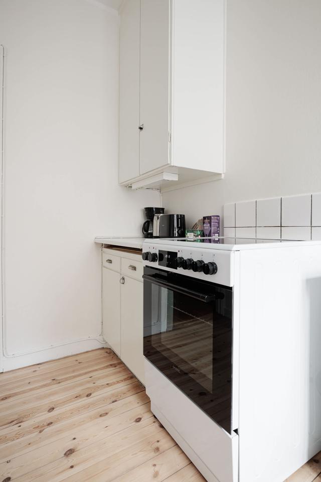 Ljust lägenhetsinteriör i Sundbyberg med minimalistisk inredning och grönskande omgivningar