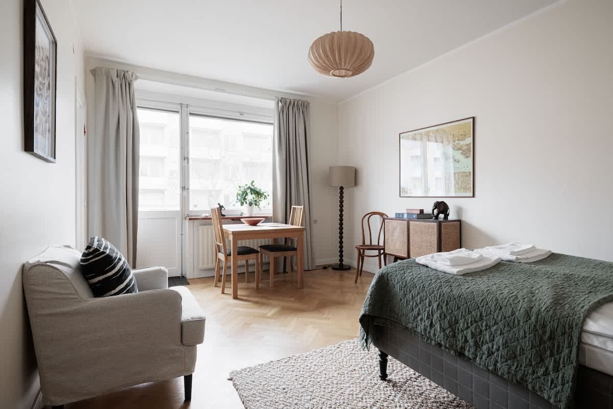 Stockholm studio apartment, 140 cm bed, dining table for two, compact kitchen, armchair, hallway