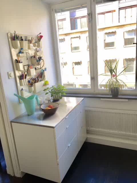 Ljust vardagsrum med soffa och konst i lägenhet på Södermalm; Stort sovrum med dubbelsäng på Södermalm; Enkelt sovrum på Södermalm; Ytterligare enkelt sovrum på Södermalm; Utrustat kök med spis och kyl på Södermalm; Privat terrass på lugn gata i Södermalm