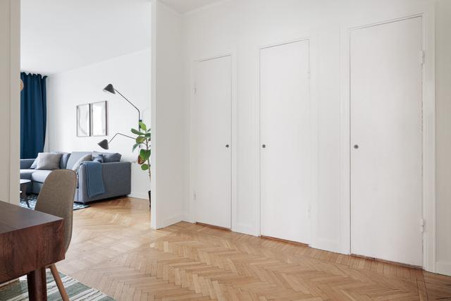 Ljust lägenhetsinteriör i Sundbyberg med minimalistisk inredning och grönskande omgivningar