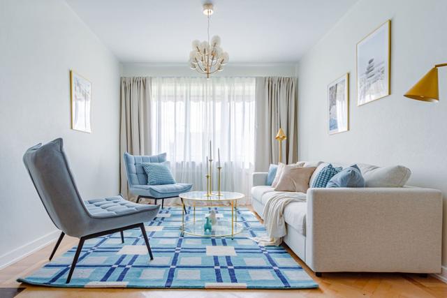 Living room with sofa bed and armchair in Kungsholmen apartment.