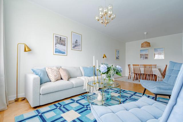 Living room with sofa bed and armchair in Kungsholmen apartment.