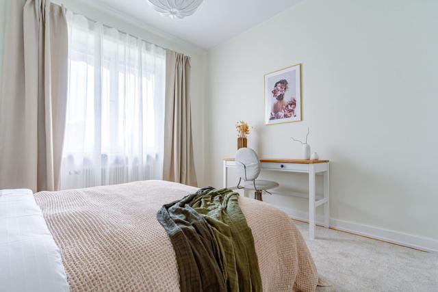 Living room with sofa bed and armchair in Kungsholmen apartment.