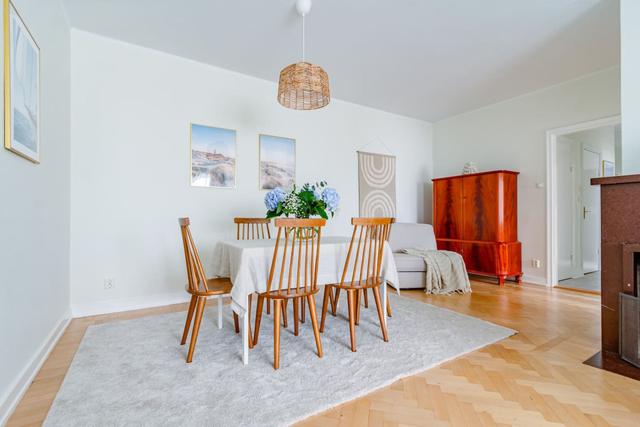 Living room with sofa bed and armchair in Kungsholmen apartment.