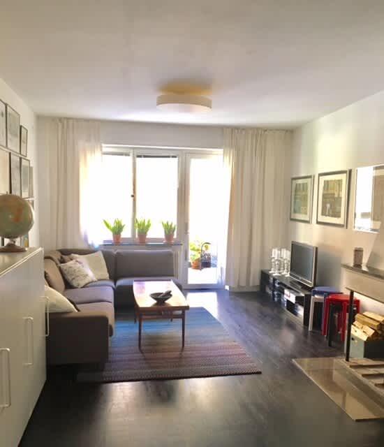 Ljust vardagsrum med soffa och konst i lägenhet på Södermalm; Stort sovrum med dubbelsäng på Södermalm; Enkelt sovrum på Södermalm; Ytterligare enkelt sovrum på Södermalm; Utrustat kök med spis och kyl på Södermalm; Privat terrass på lugn gata i Södermalm